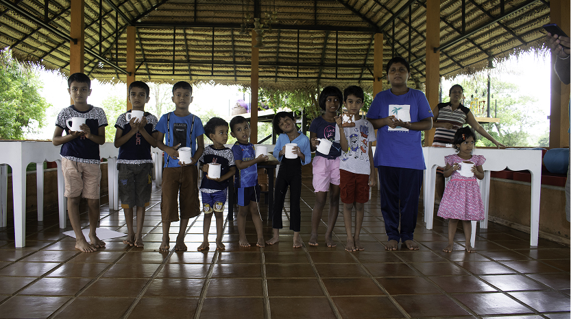 Children proudly holding their creations after a workshop at an eco lodge Sri Lanka promoting awareness