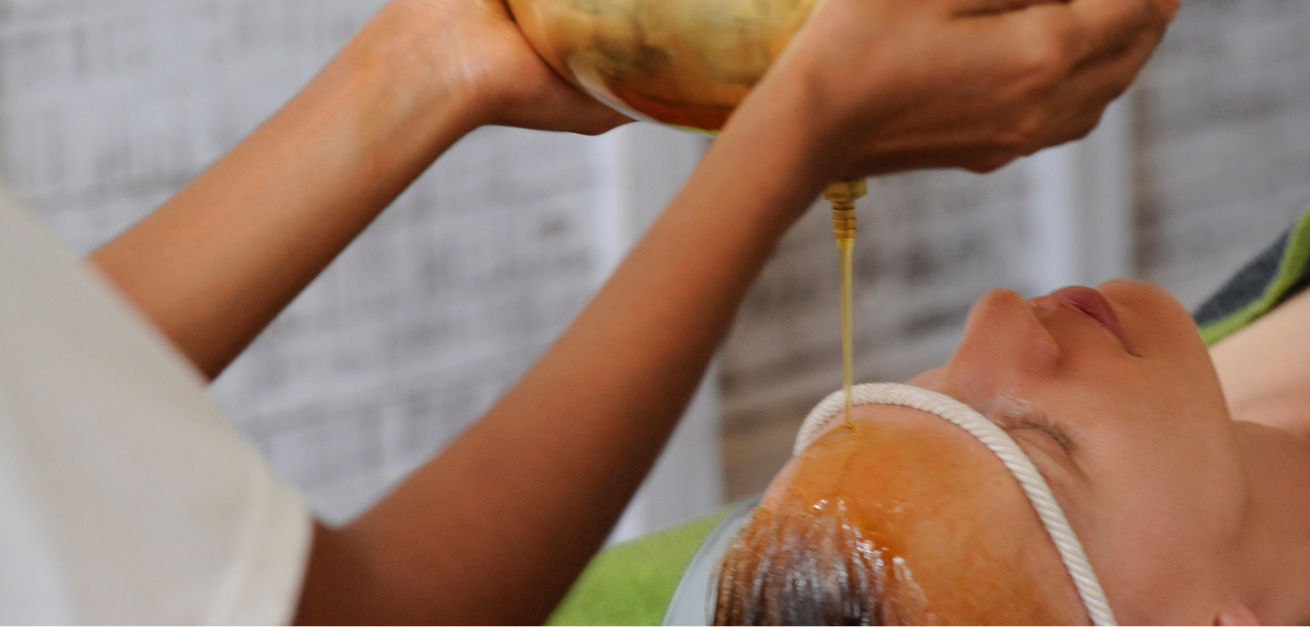 Traditional Ayurvedic oil flow on forehead: Ayurveda retreat Sri Lanka at Ayurvie Weligama