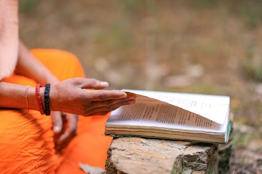Ayurvedic practitioner reading traditional Ayurveda text regarding holistic healing