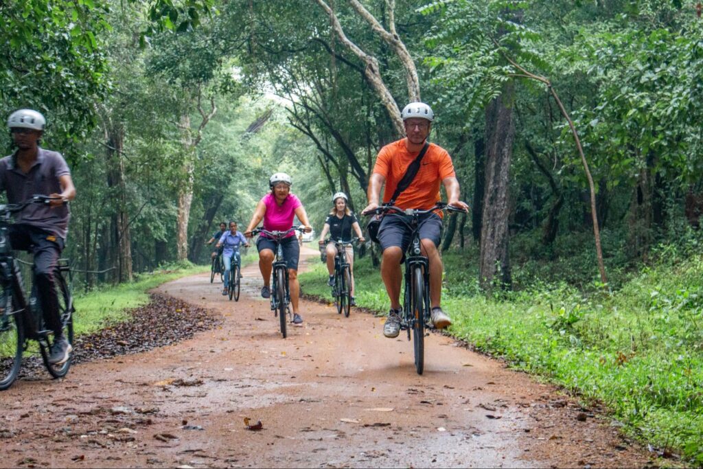 Travellers cycling through countryside trails near Sigiriya during a village tour experience