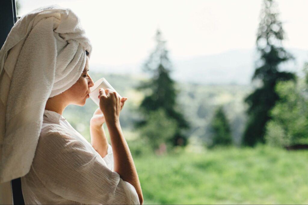 Traveller enjoying a cup of Ceylon tea while overlooking Sri Lanka’s hill country landscape