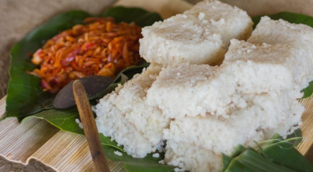 Sri Lankan kiribath, milk rice served on a lotus leaf with spicy sambol