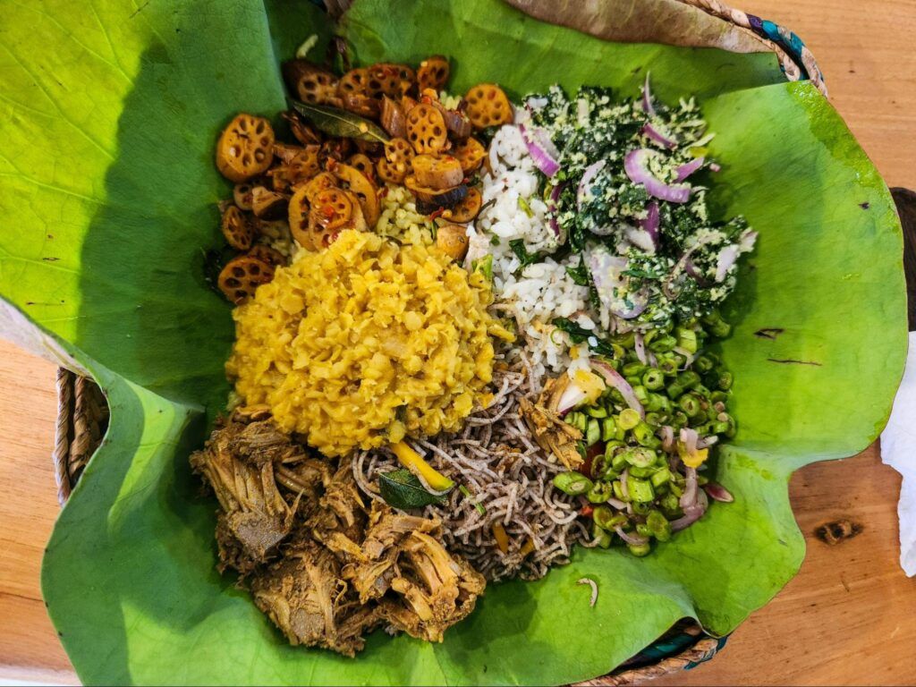 Sri Lankan rice and curry served on a lotus leaf with traditional side dishes