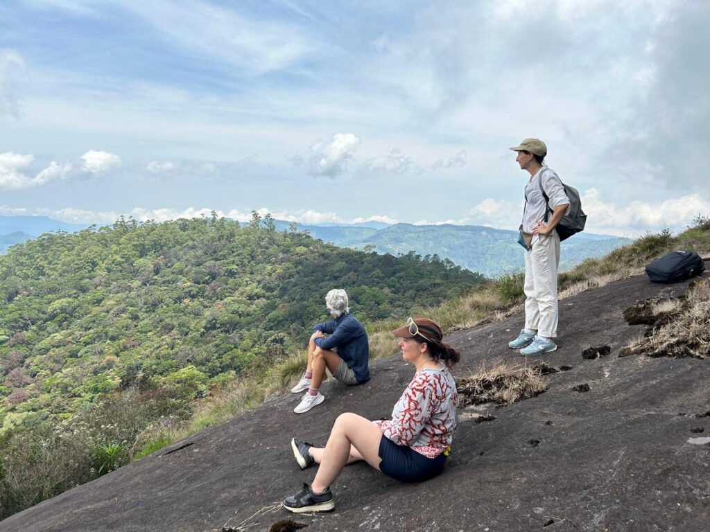 Hikers resting at Mahakudugala viewpoint during a scenic hiking trail in Nuwara Eliya, Sri Lanka