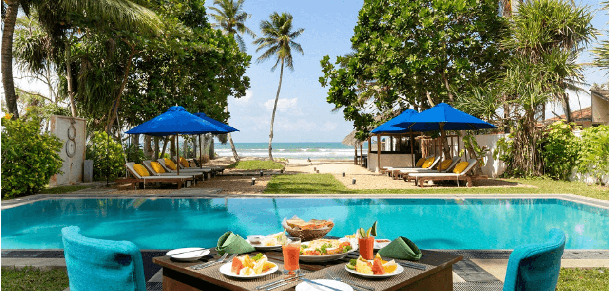 Fruit platter set up beside the pool at Parangi Weligama Bay, ocean in the background.